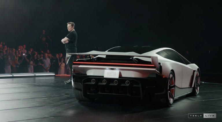 Elon Musk đứng bên cạnh Tesla Roadster.jfif